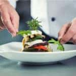 A chef at a Milwaukee, WI restaurant is preparing a high end plate of food.