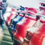 Many blue, red, and white car are shown parked bumper to bumper in one of the used car lots in Milwaukee.